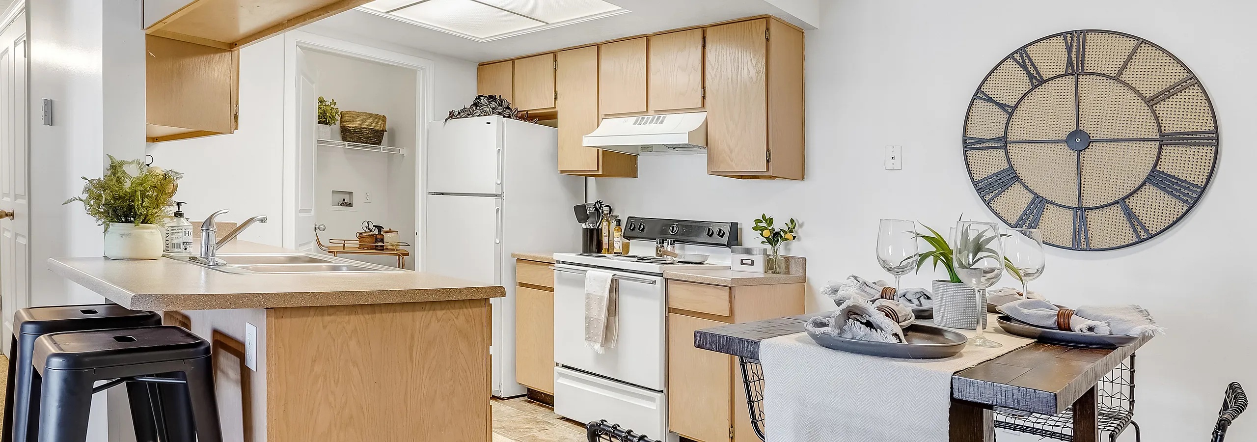 Elegant kitchen with light wood cabinets, breakfast bar, and stylish dining area.