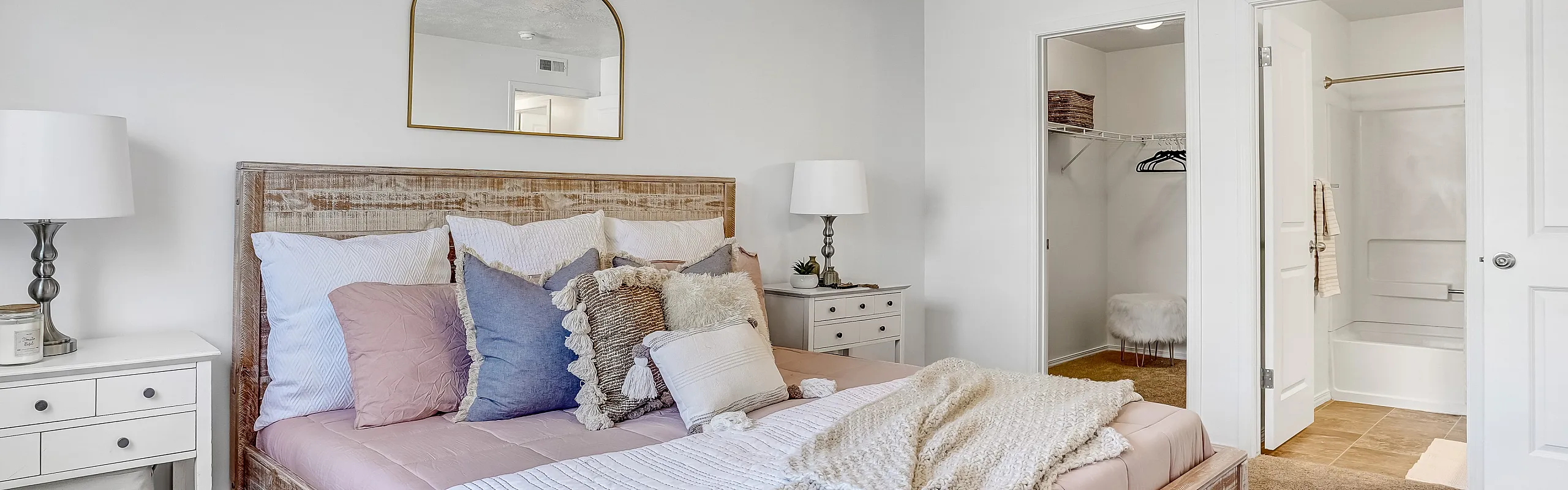 Inviting bedroom with rustic wooden bed, soft bedding, and elegant decor.