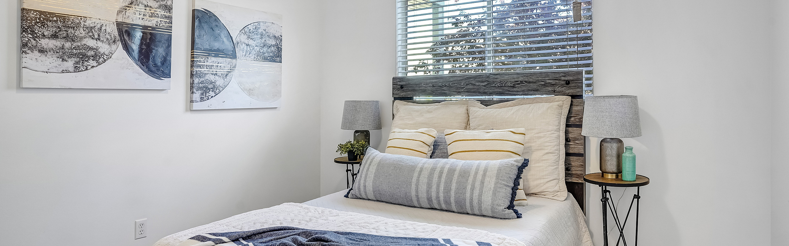 Inviting bedroom with a plush bed, stylish decor, soft lighting, and artistic wall accents.