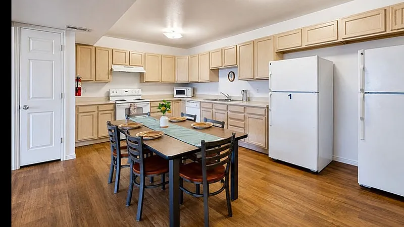Bright and spacious kitchen with modern appliances, ample cabinetry, and a charming dining area on elegant wood flooring.