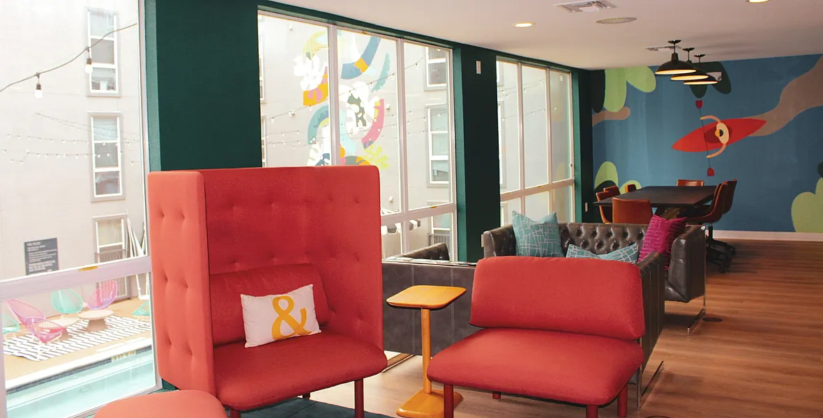 Vibrant lounge area with colorful seating, modern decor, and large windows offering ample natural light.