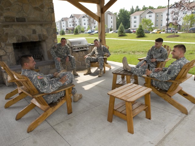 Soldiers sitting around outdoor fireplace