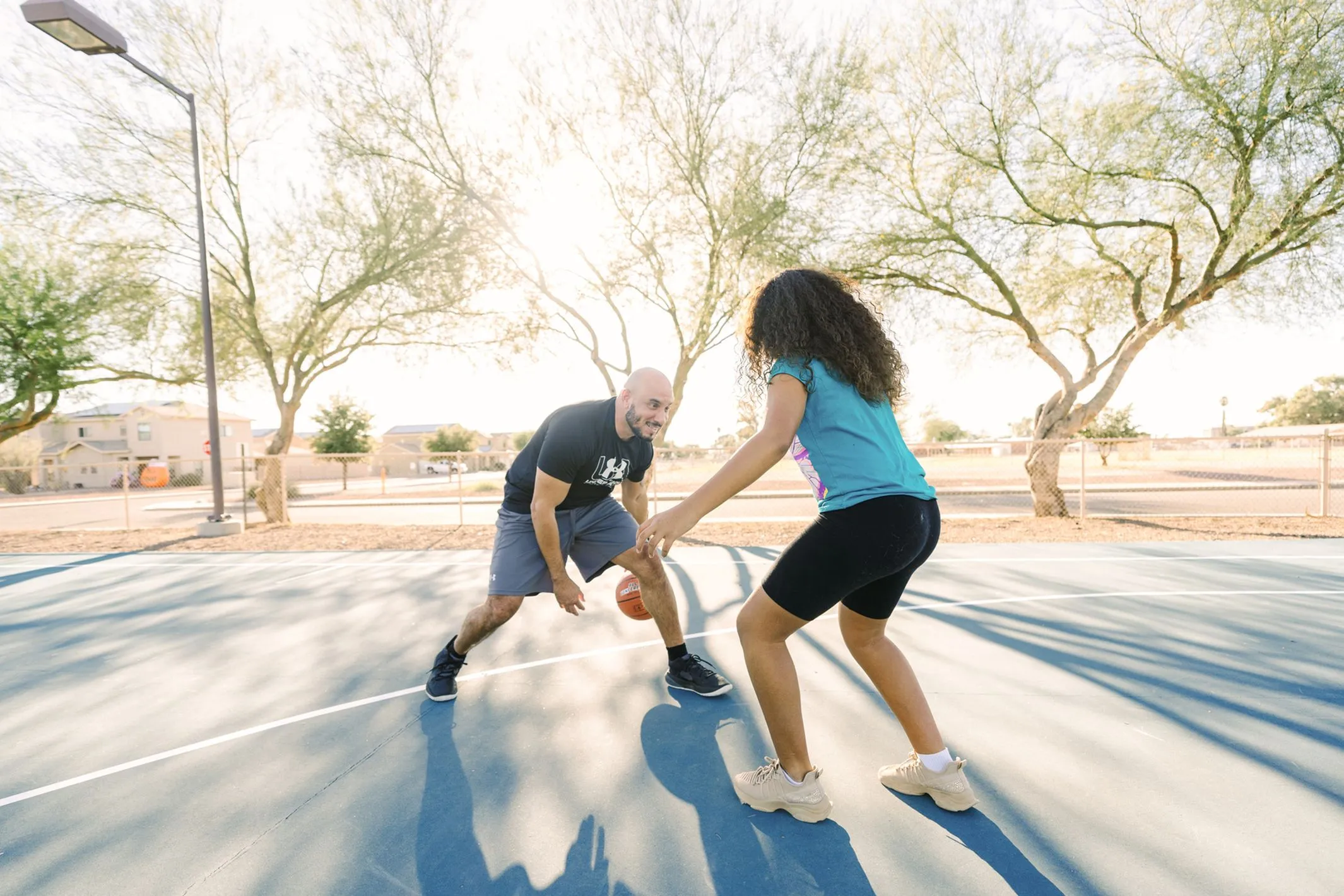 Two people playing basketball together