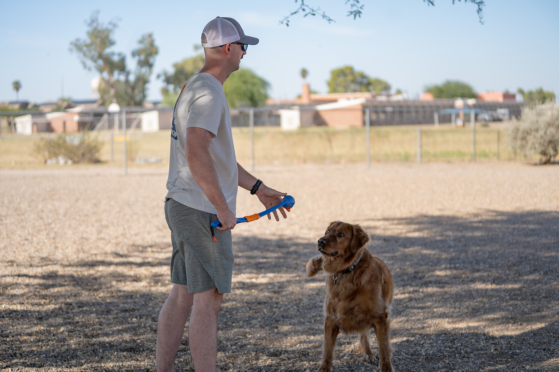 Man playing fetch with dog at dog park