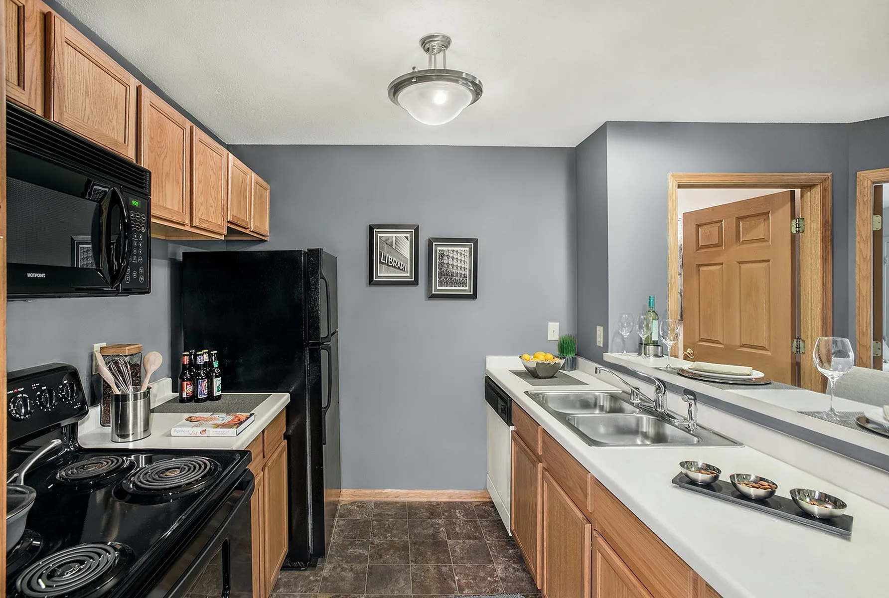 Modern kitchen with sleek black appliances, cozy wooden cabinetry, and elegant gray walls, perfect for culinary creativity.