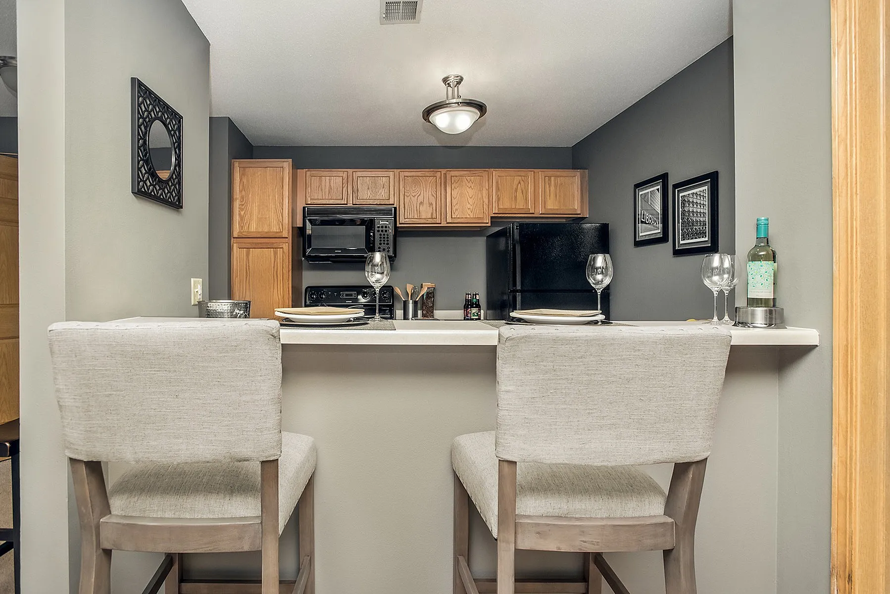 Inviting kitchen with modern cabinetry, elegant countertop dining for two, and stylish decor.