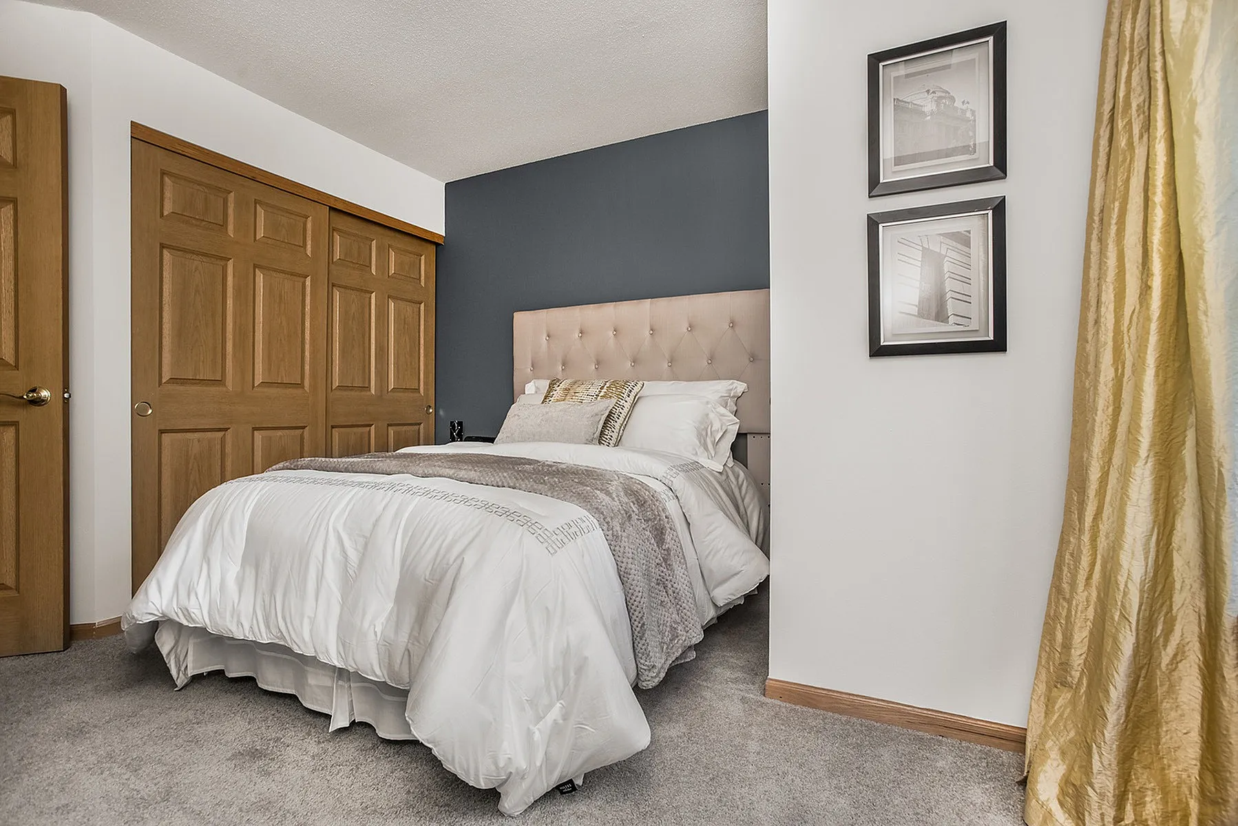 Cozy bedroom with plush bed, elegant decor, and warm wooden closet doors, inviting relaxation and comfort.