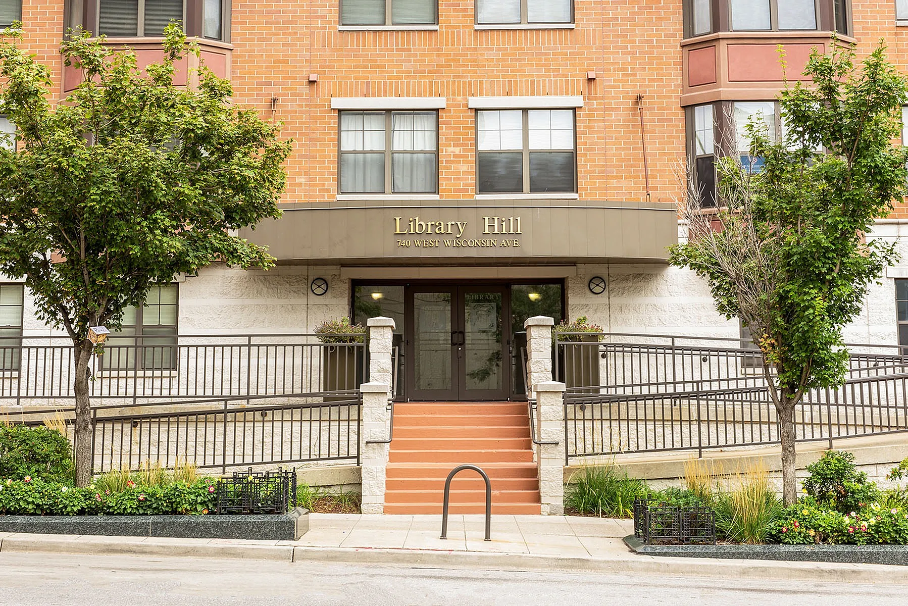 Charming Library Hill entrance featuring elegant architecture and inviting greenery at 740 West Wisconsin Ave.