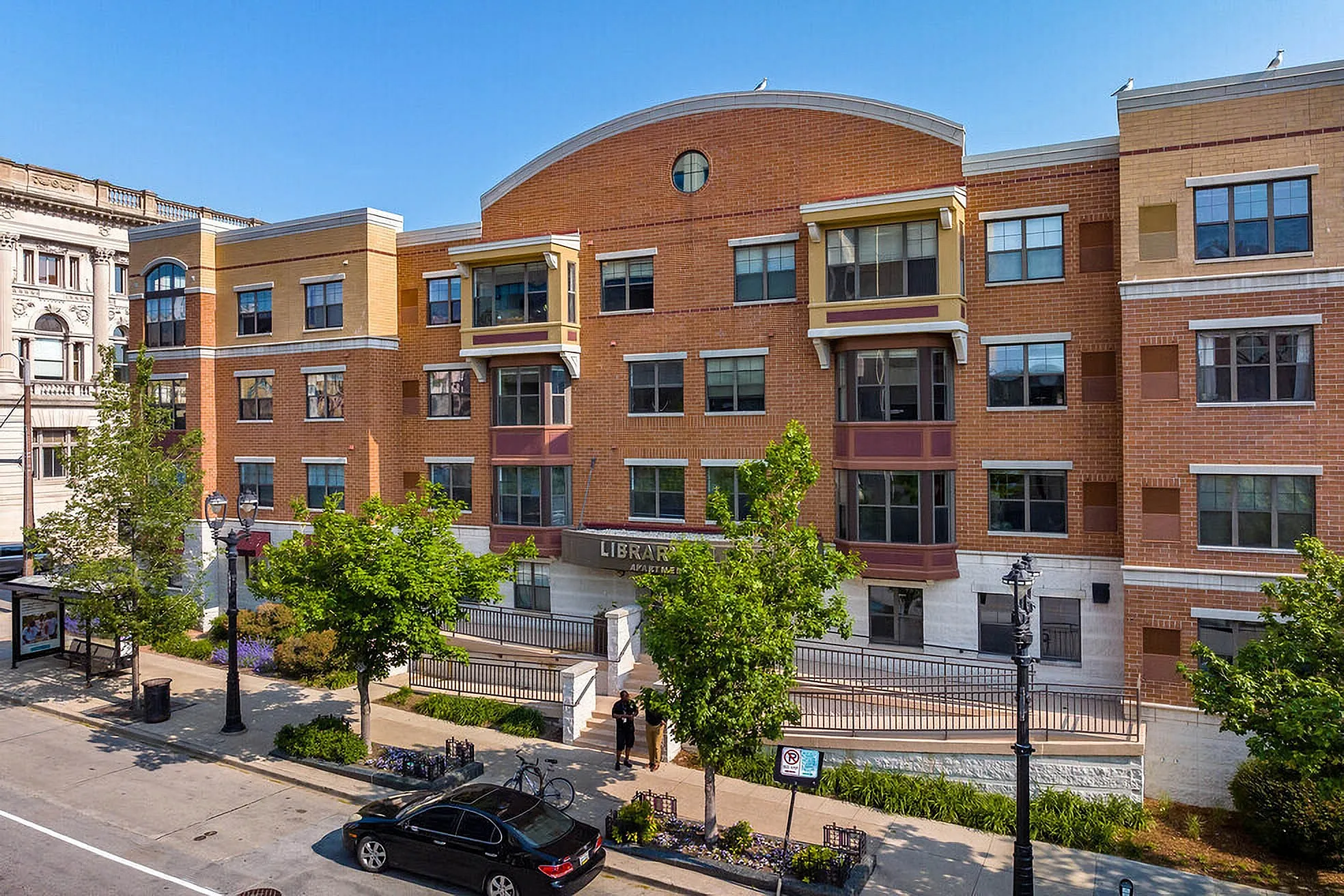 Charming urban apartment building with modern design, featuring large windows and attractive brick exterior, ideal for city living.