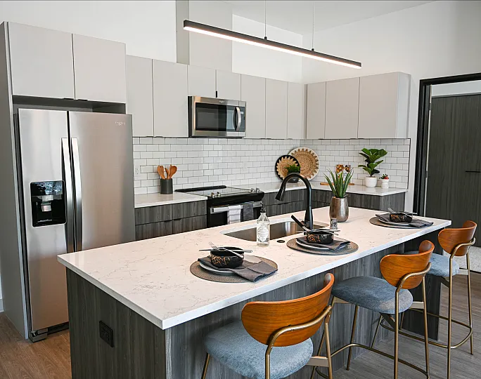 Modern kitchen with sleek appliances, elegant island seating, and stylish decor, perfect for entertaining.