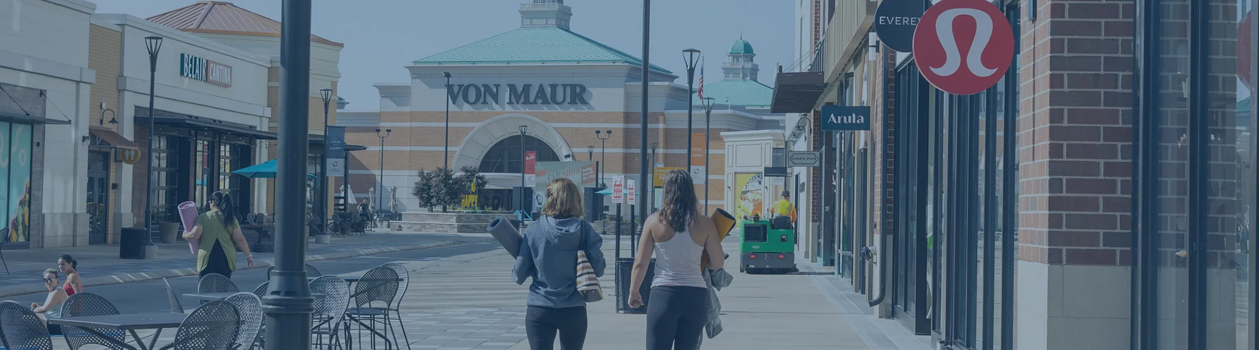 Charming shopping district with elegant stores, outdoor seating, and a lively atmosphere, perfect for a sunny day outing.