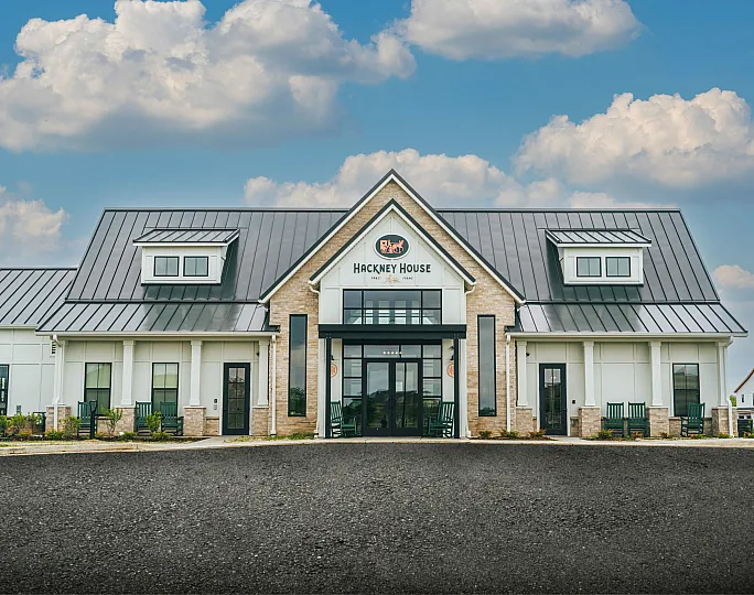 Charming modern building with sleek metal roof and inviting front porch, perfect for community gatherings.