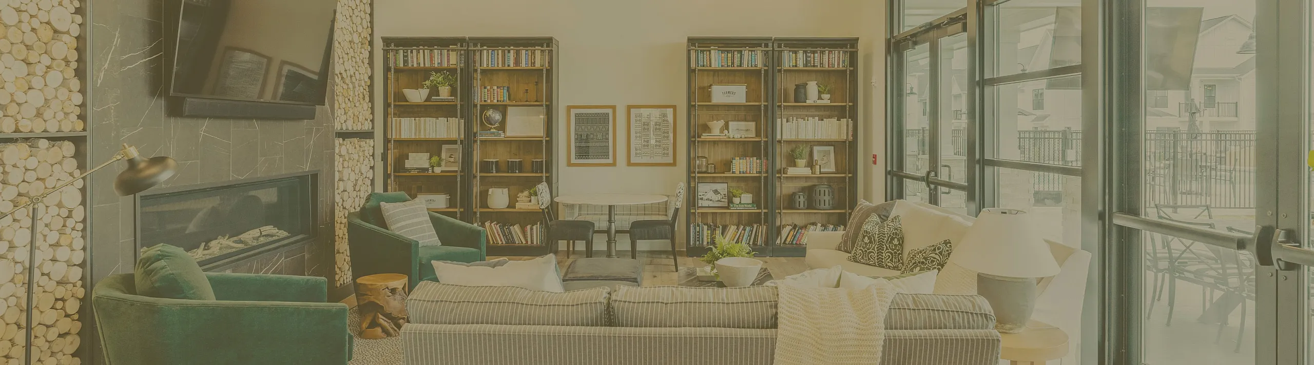 Elegant apartment lounge with cozy seating, modern fireplace, and expansive windows offering natural light. Perfect for relaxation and entertainment.