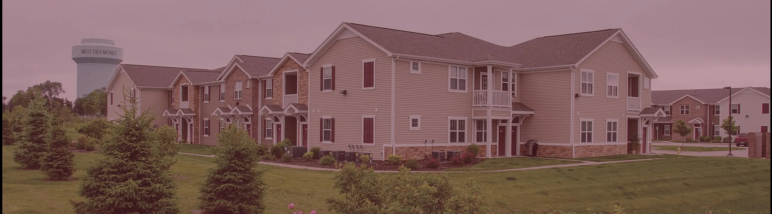 Charming suburban apartments with lush green landscaping and blooming flowers in a serene neighborhood setting.