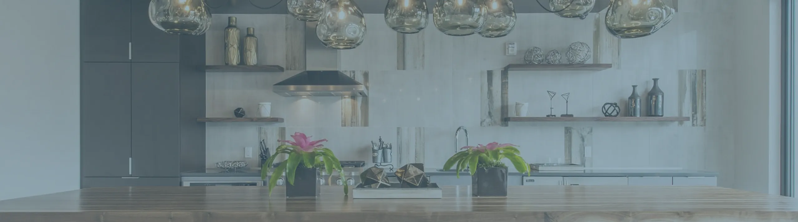 Modern industrial kitchen with a large wooden table, chic pendant lights, and sleek open shelves, perfect for entertaining.