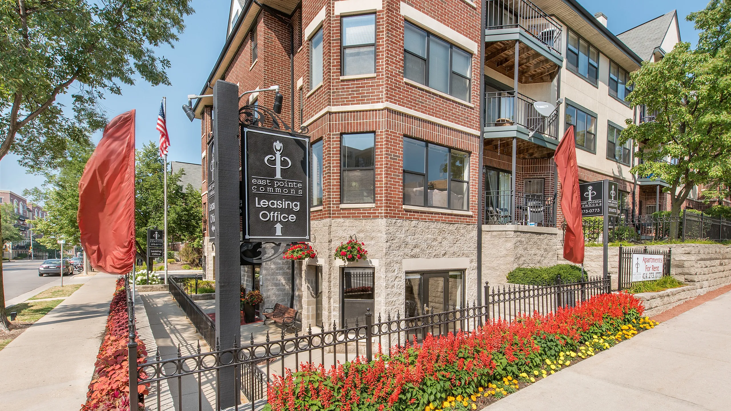 Charming brick apartment building with vibrant landscaping at East Pointe Commons and welcoming leasing office.