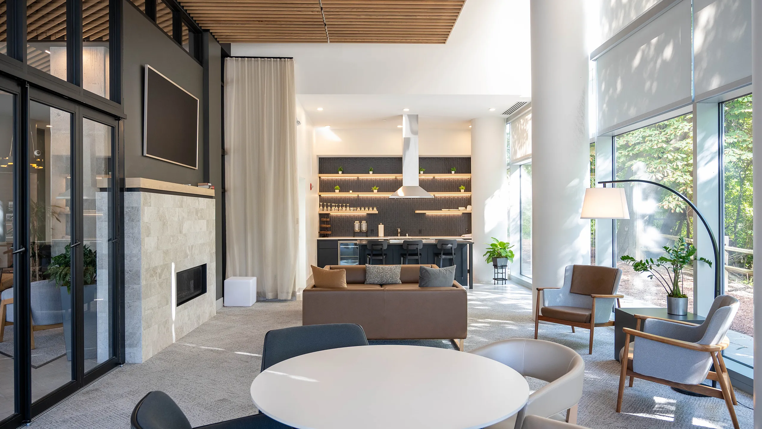 Modern living area with stylish furniture, large windows, and open-plan layout. Features a sleek kitchen, cozy seating, and abundant natural light.