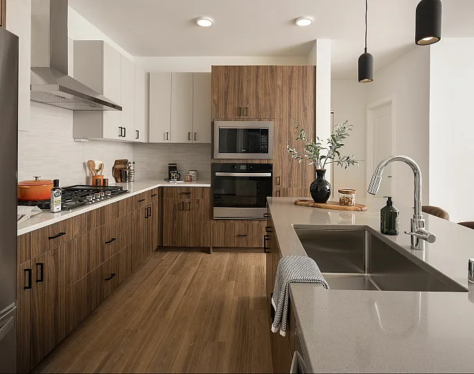 Modern kitchen with sleek stainless steel appliances, chic wood cabinetry, and stylish pendant lighting over a spacious island.