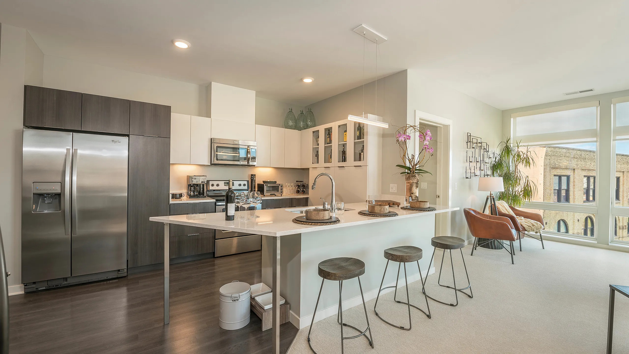 Contemporary open-plan kitchen and living area with sleek appliances, a large island, and ample natural light.