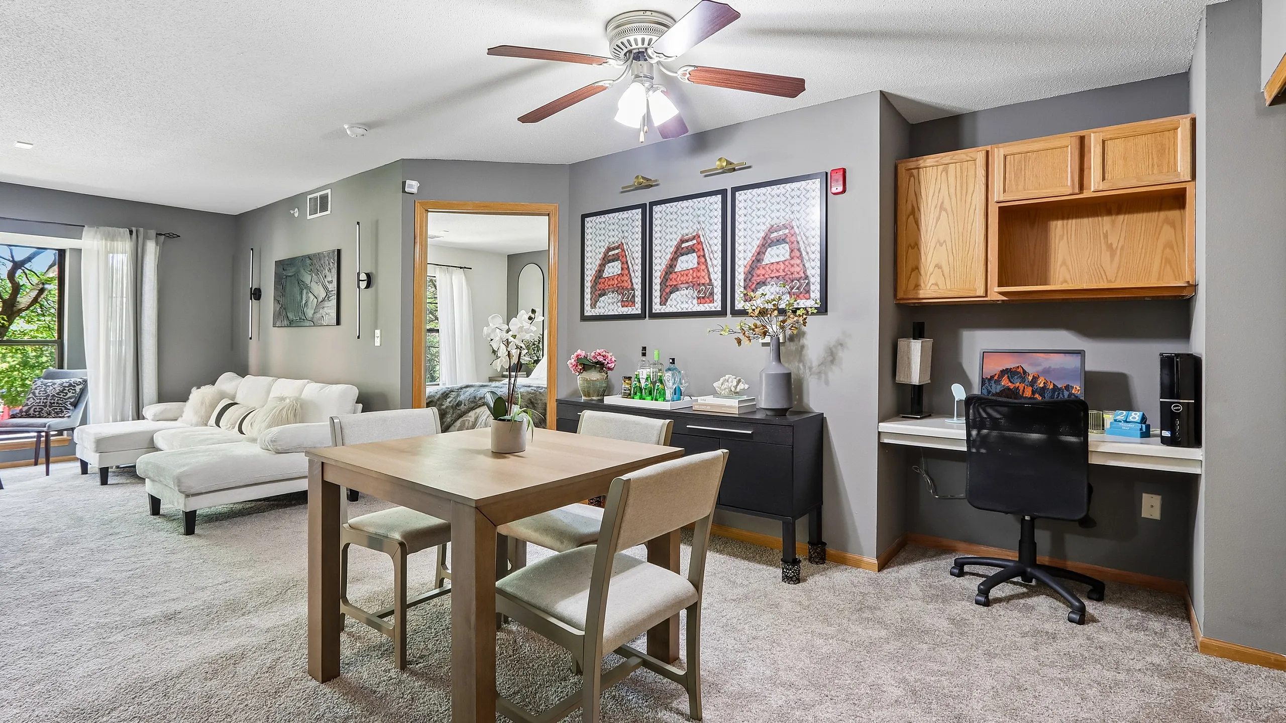 Bright open-concept living and dining area featuring elegant decor, a cozy seating arrangement, and a workspace nook; perfect for modern living.