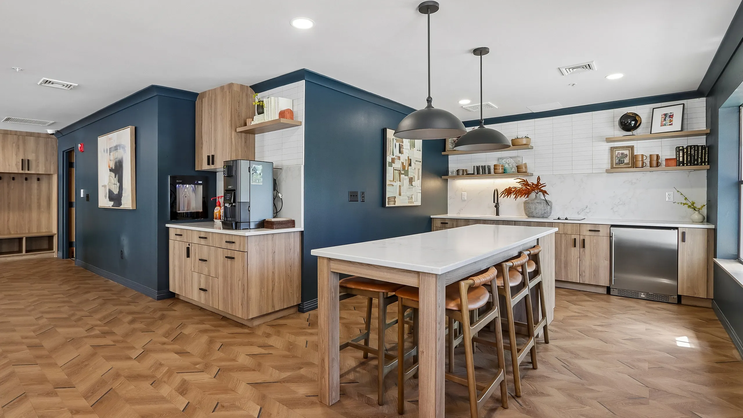 Modern kitchen with sleek wooden cabinetry, elegant blue accent walls, and a spacious island, ideal for gatherings and culinary creations.