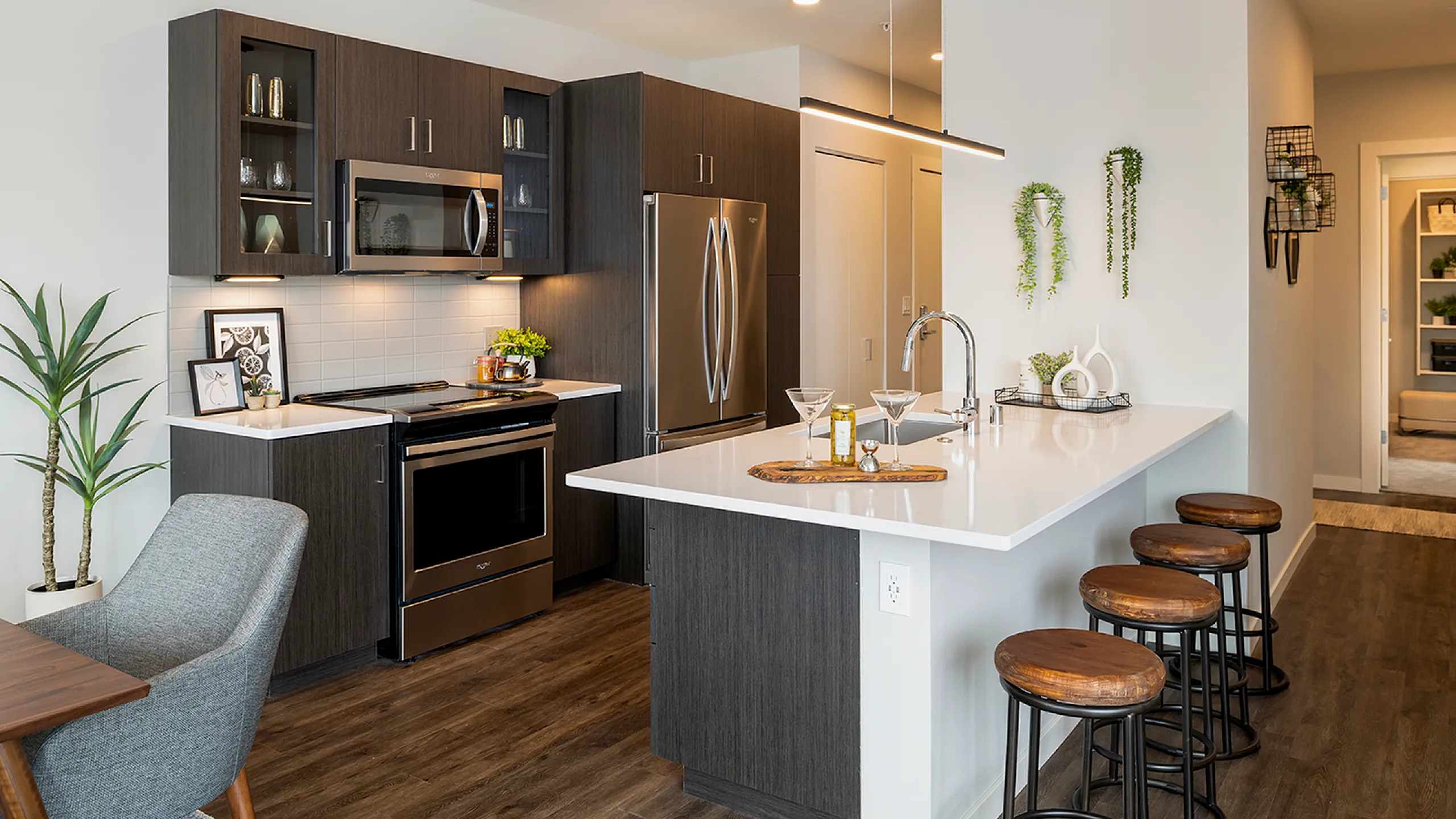 Modern kitchen with sleek cabinets, stainless steel appliances, and a stylish breakfast bar in a cozy apartment setting.