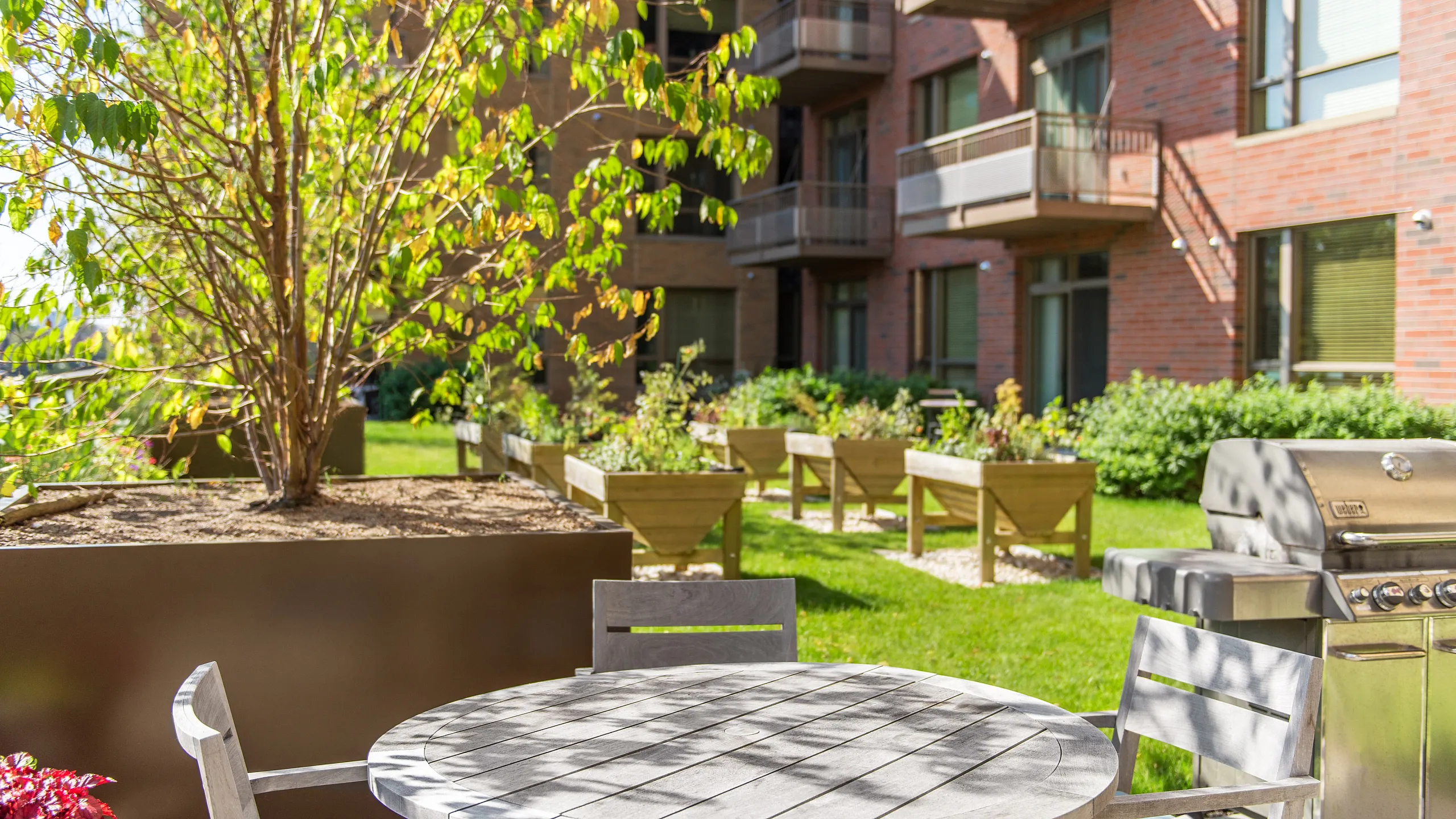 Charming apartment patio with stylish outdoor furniture and vibrant garden planters, perfect for relaxing and entertaining.