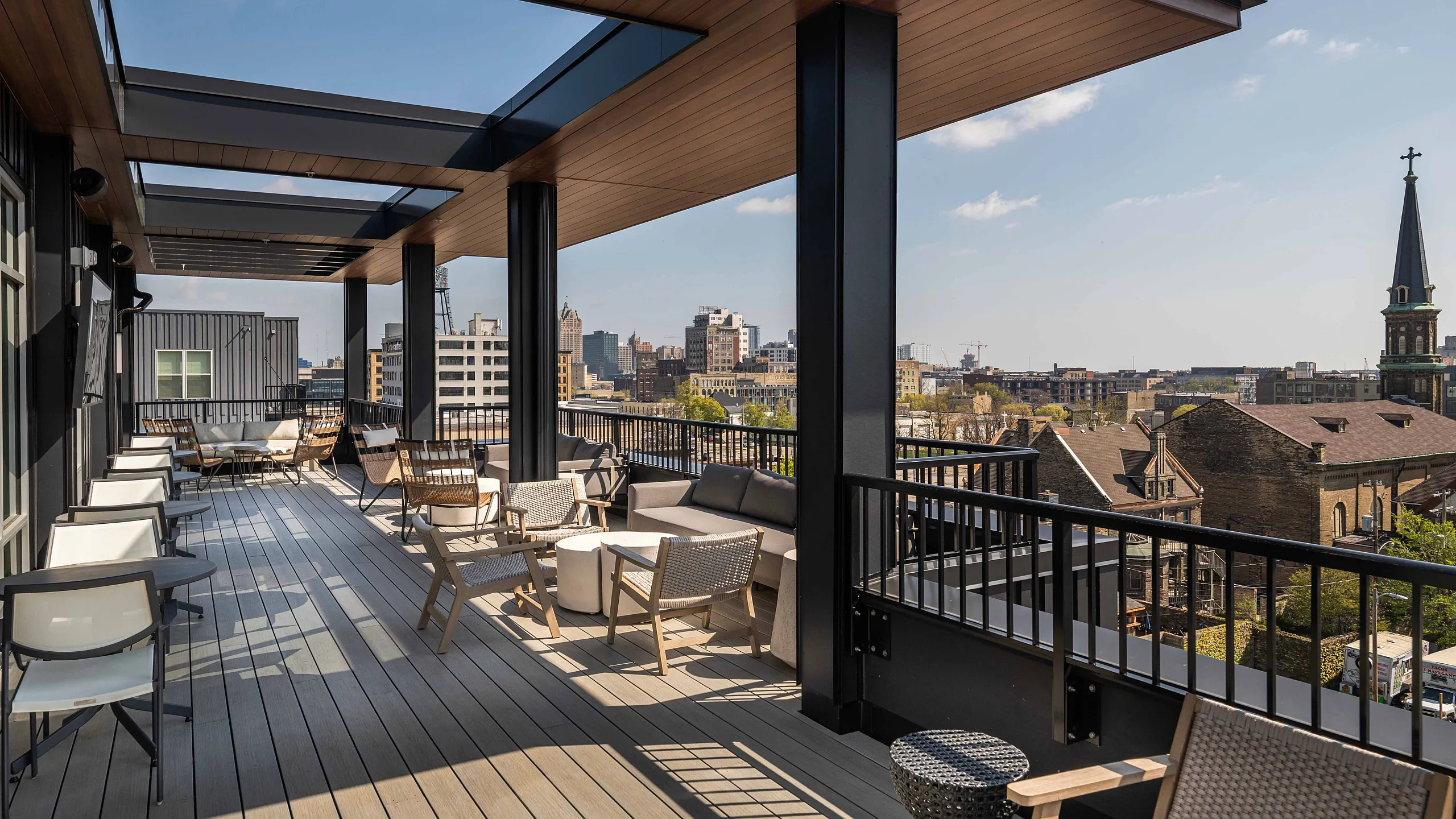 Chic urban rooftop terrace with stylish seating and panoramic city views, featuring modern pergola design.