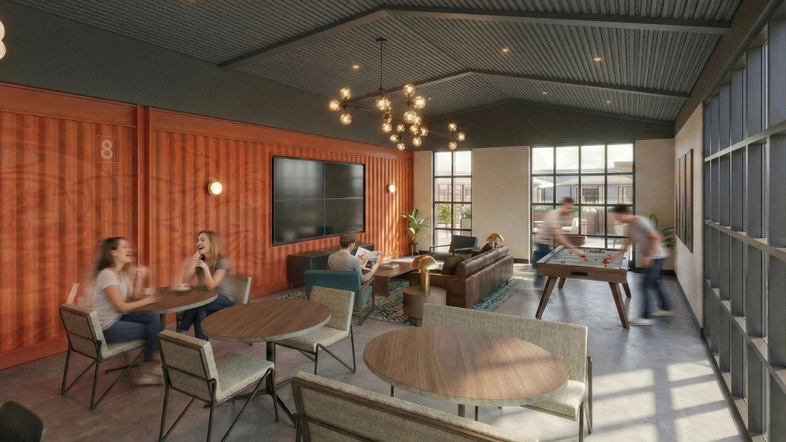 Contemporary common area with stylish seating, large TV, and recreational foosball table, enhanced by ample natural light and modern lighting fixtures.