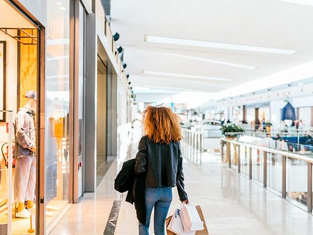 Modern shopping mall with sleek architecture, showcasing luxury storefronts and vibrant lighting.