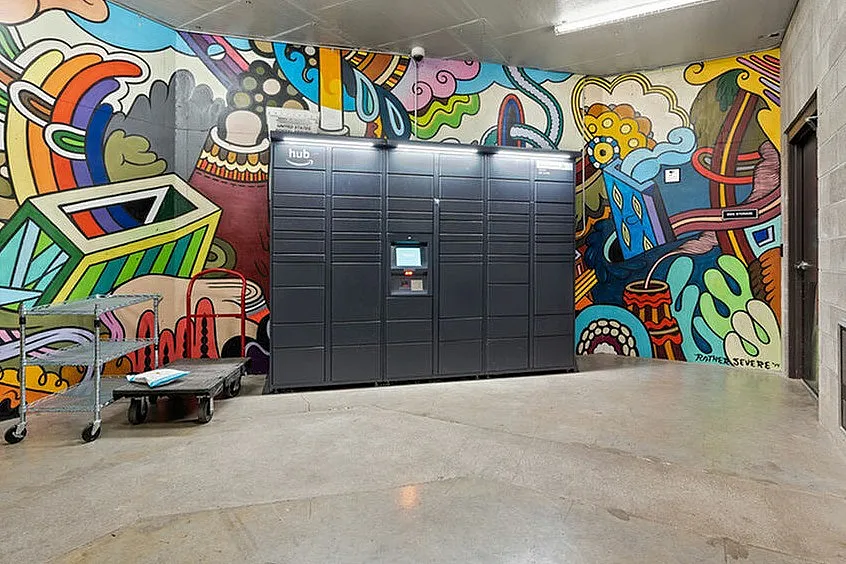 Colorful mural with a secure package locker system in a contemporary apartment building.