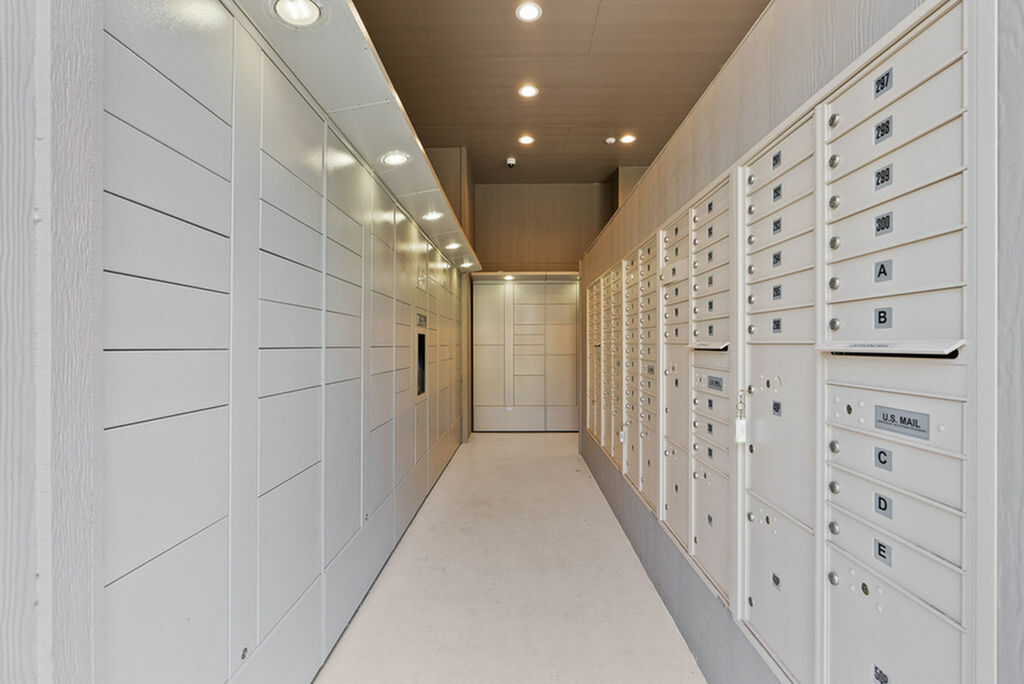 Contemporary mailroom with sleek, organized lockers and bright lighting for a modern apartment complex.