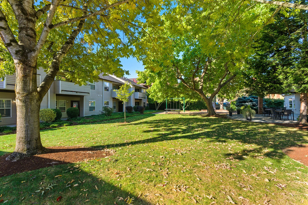 Beautiful apartment complex surrounded by lush greenery and mature trees, offering a peaceful outdoor escape.
