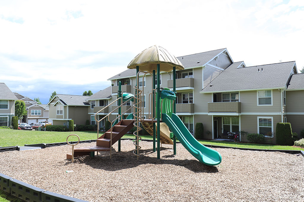 Charming apartment complex with well-maintained gardens and a vibrant playground, ideal for families.