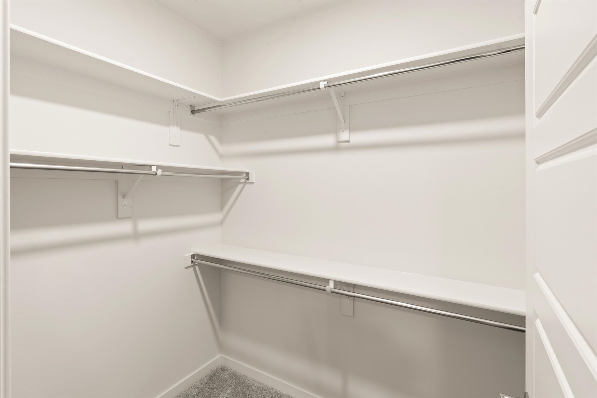Spacious walk-in closet with ample shelving and hanging space, perfect for organized living.