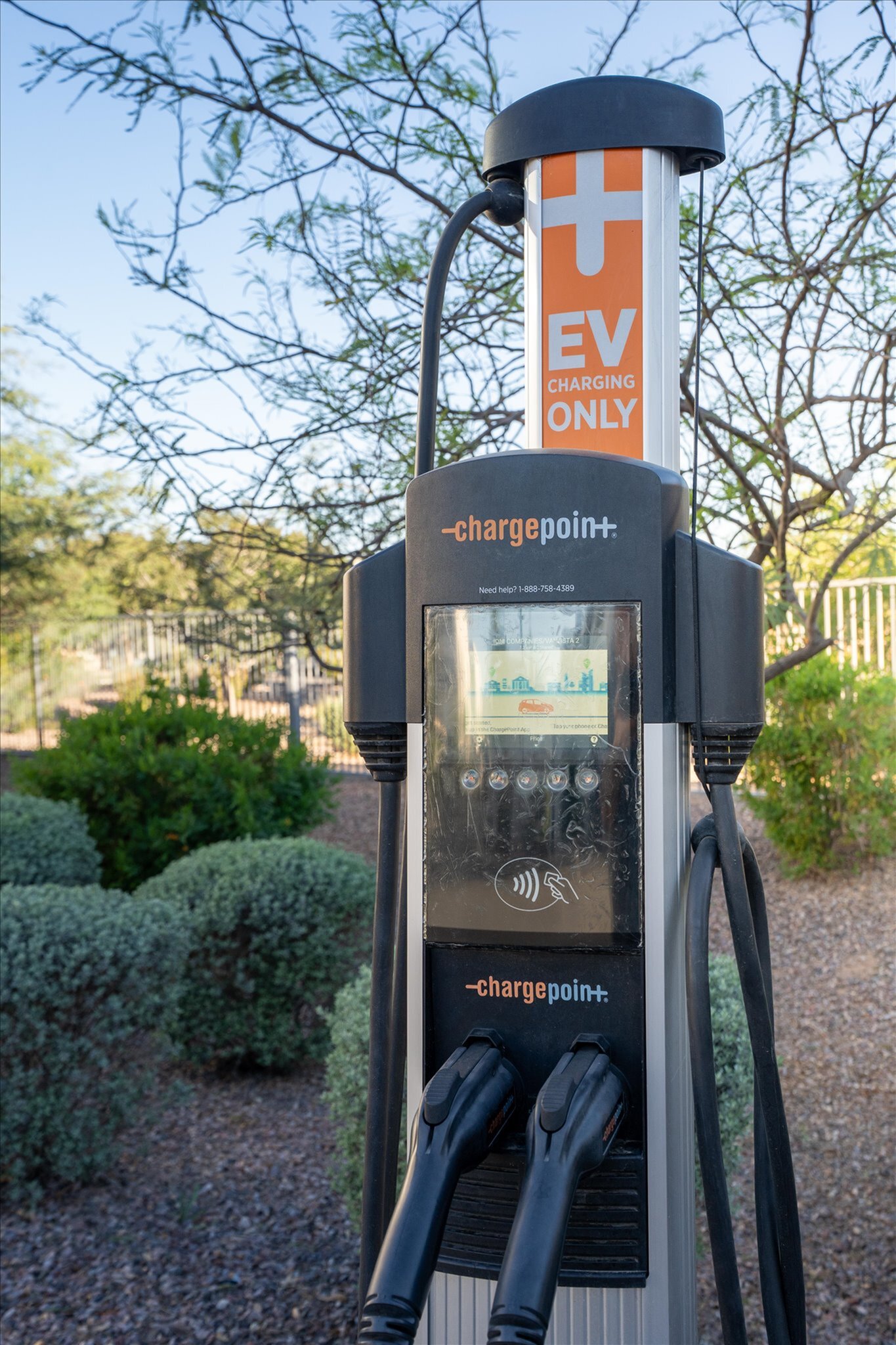 Modern EV charging station in a lush outdoor setting, showcasing sustainability and green technology.