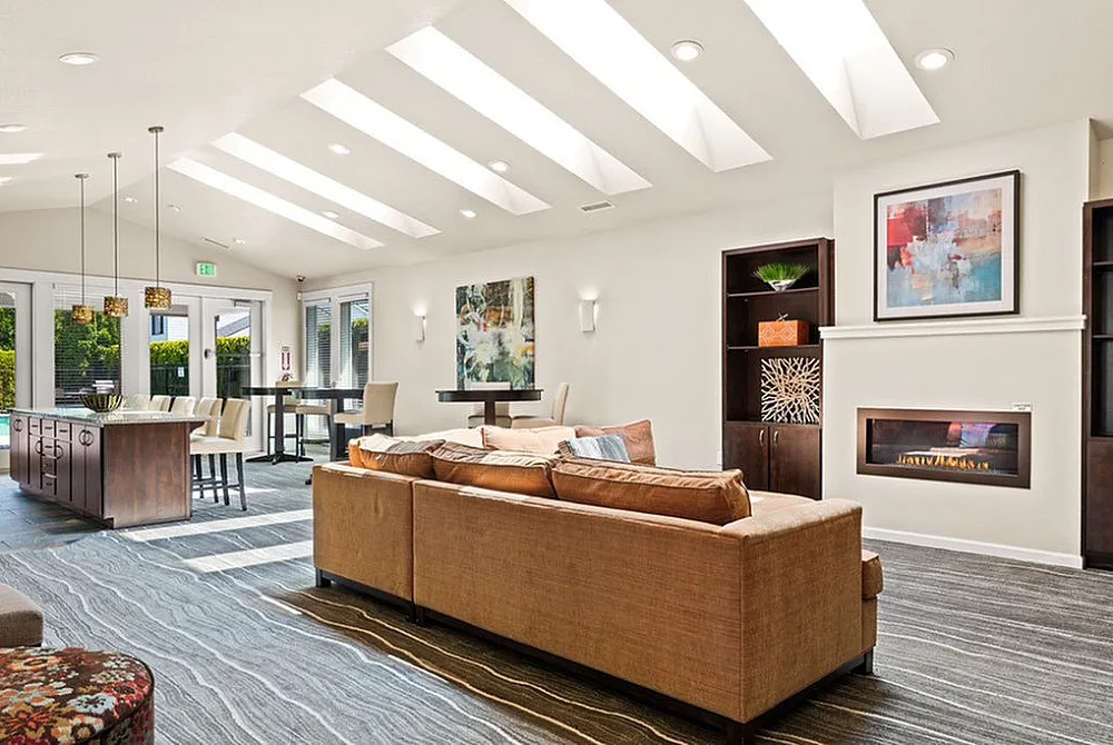 Bright and modern living space with skylights, cozy fireplace, and elegant decor for a warm ambiance.