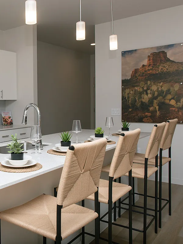 Modern kitchen with sleek white cabinetry, stainless steel appliances, and chic pendant lighting over a spacious island with bar seating and contemporary decor.