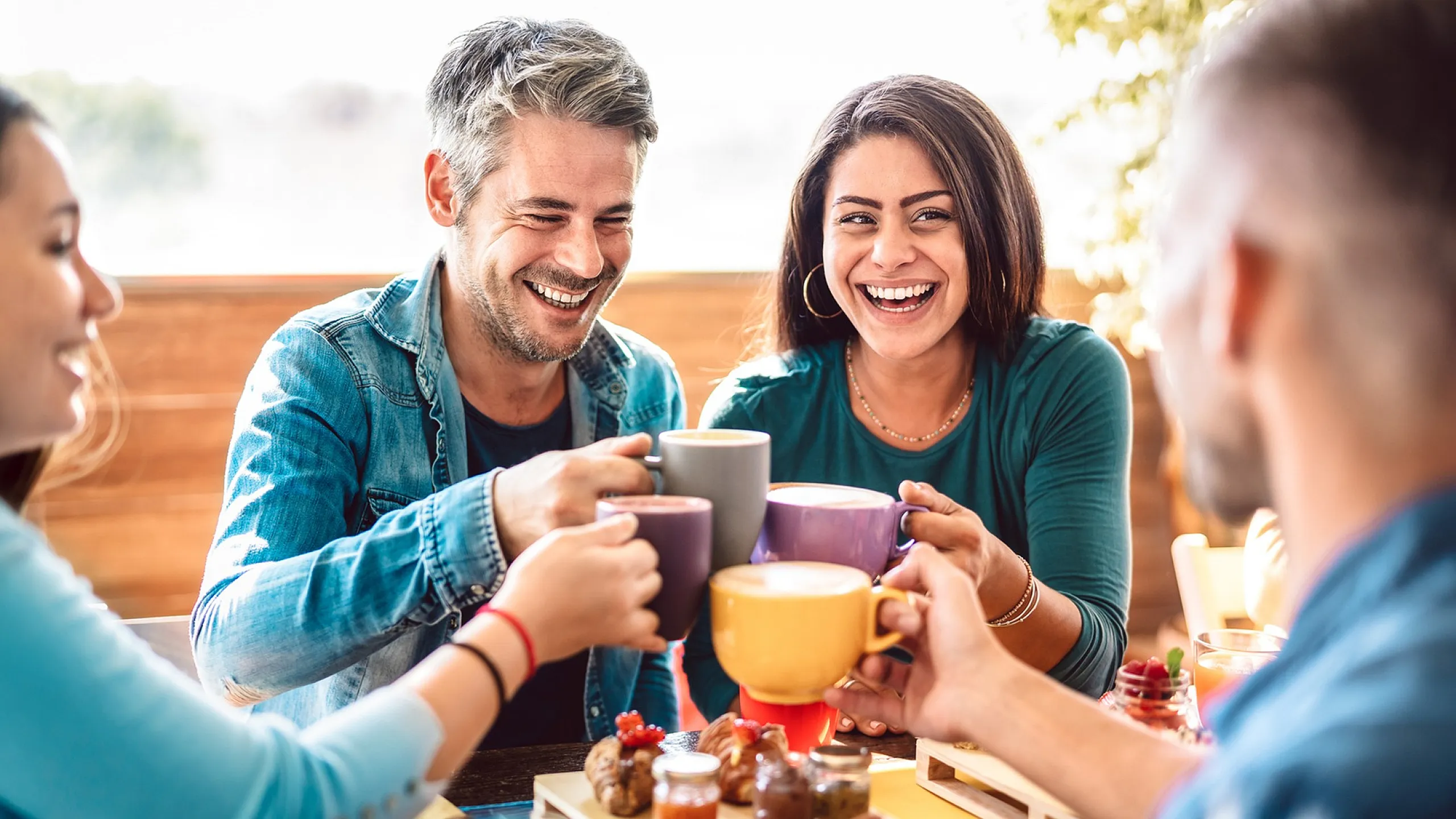 Joyful group of friends enjoying coffee and breakfast, symbolizing community and vibrant social living.