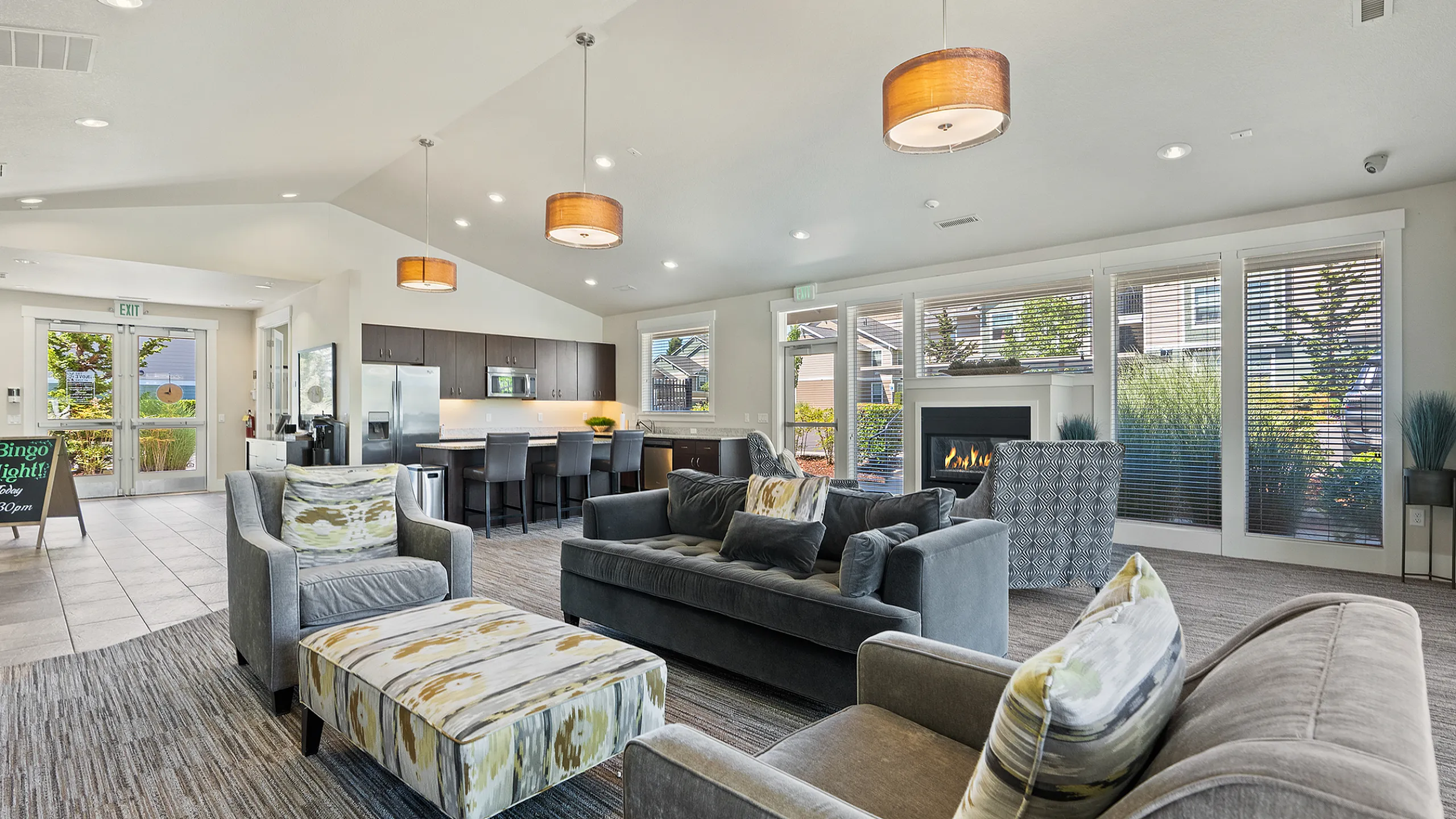 Inviting open-concept living space featuring plush seating, a modern kitchen, and a cozy fireplace, perfect for entertaining.