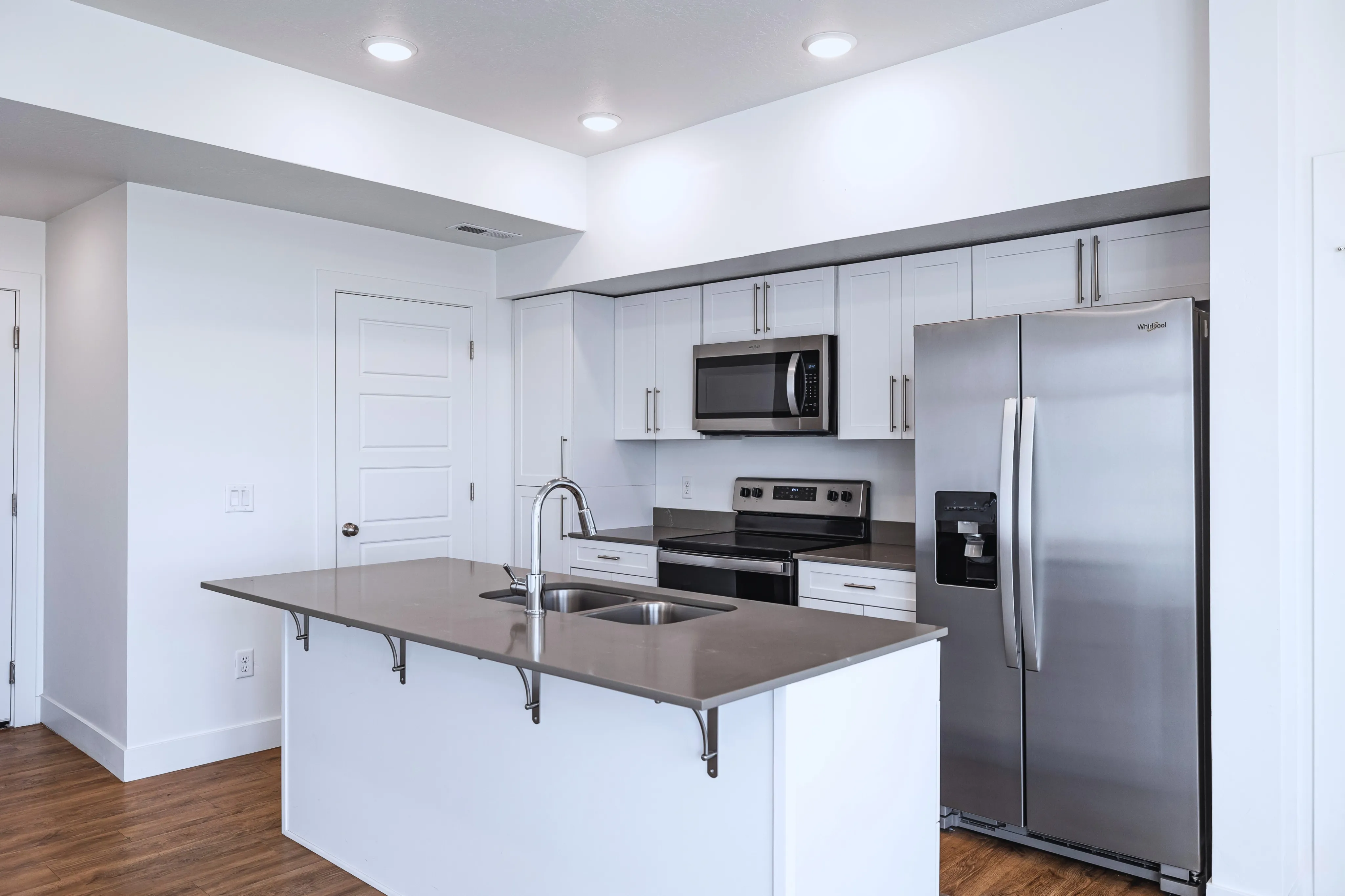 Sleek modern kitchen with stainless steel appliances, elegant white cabinetry, and a spacious island countertop.