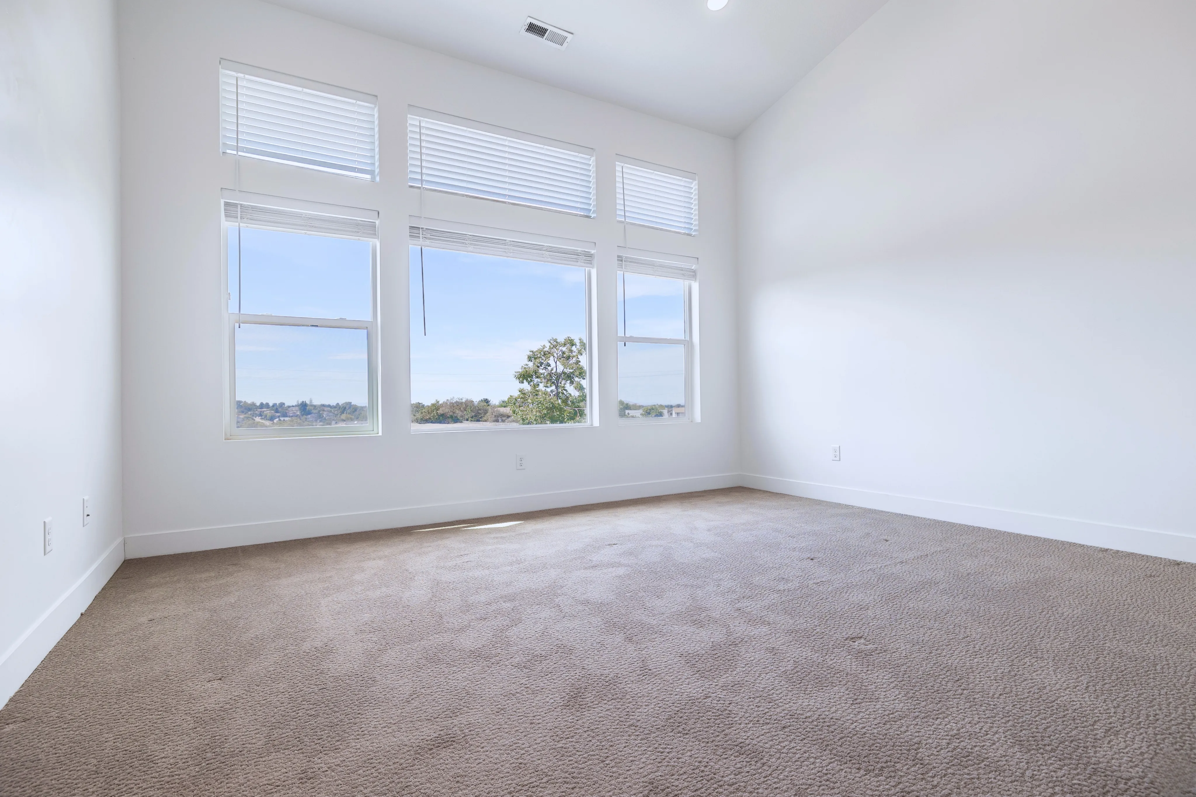 Bright and spacious room with large windows offering scenic views, ideal for a cozy bedroom or serene office space.
