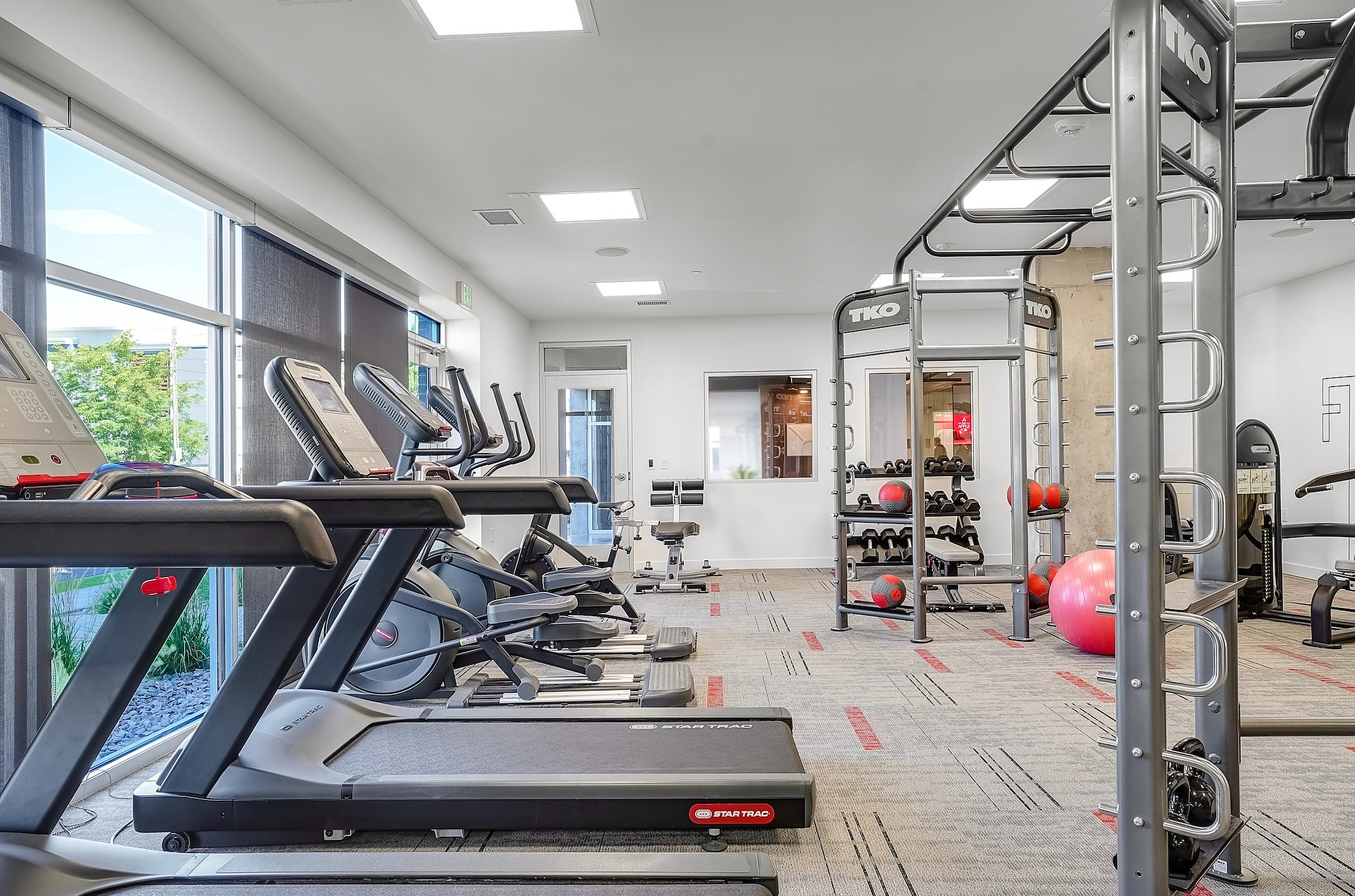 Modern gym with state-of-the-art treadmills and versatile workout equipment in a bright, spacious setting.