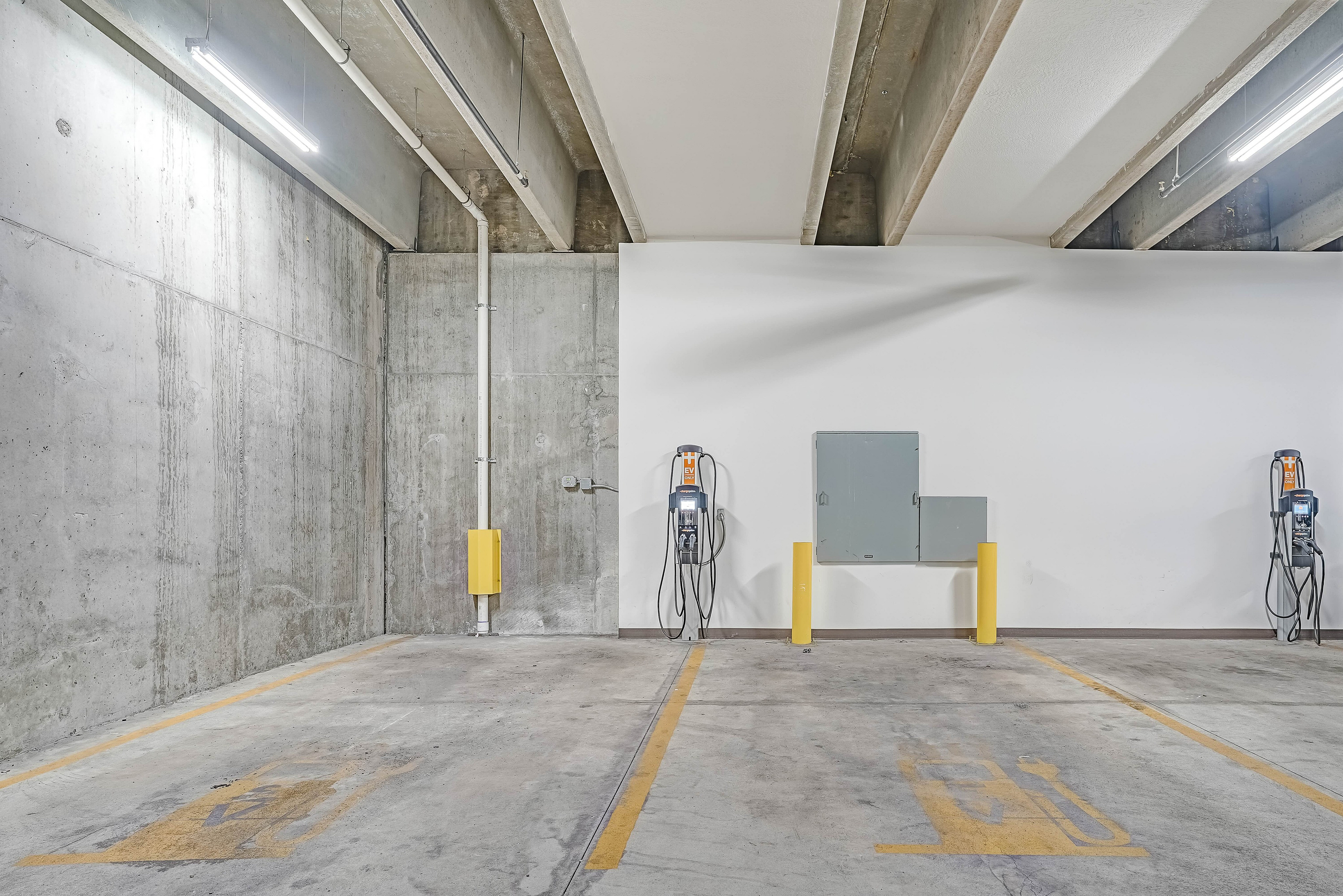 Modern parking garage with electric vehicle charging stations, showcasing a sleek and convenient amenity for residents.