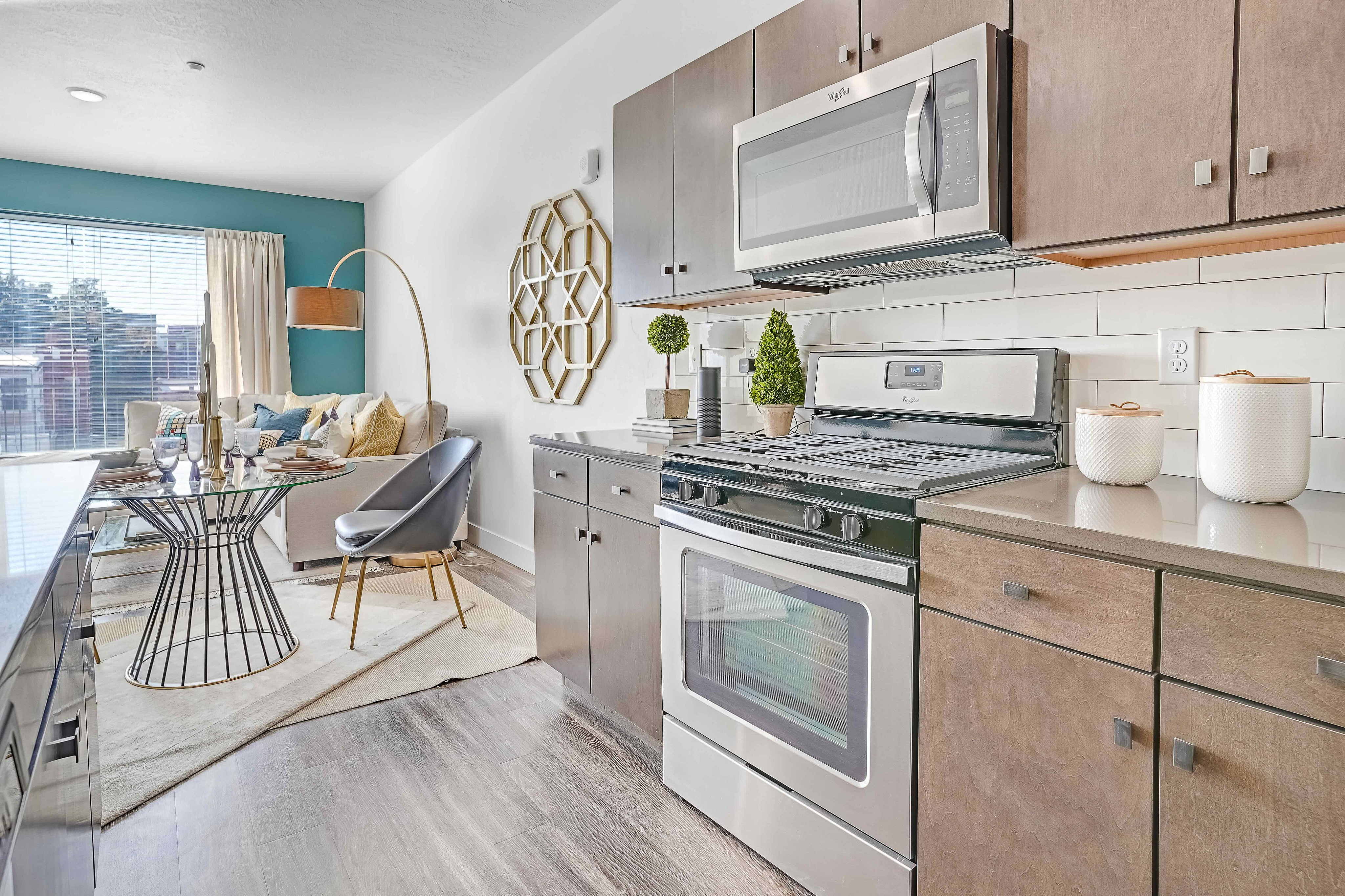 Bright and modern open-concept kitchen and living area with sleek appliances, elegant decor, and a cozy seating arrangement.