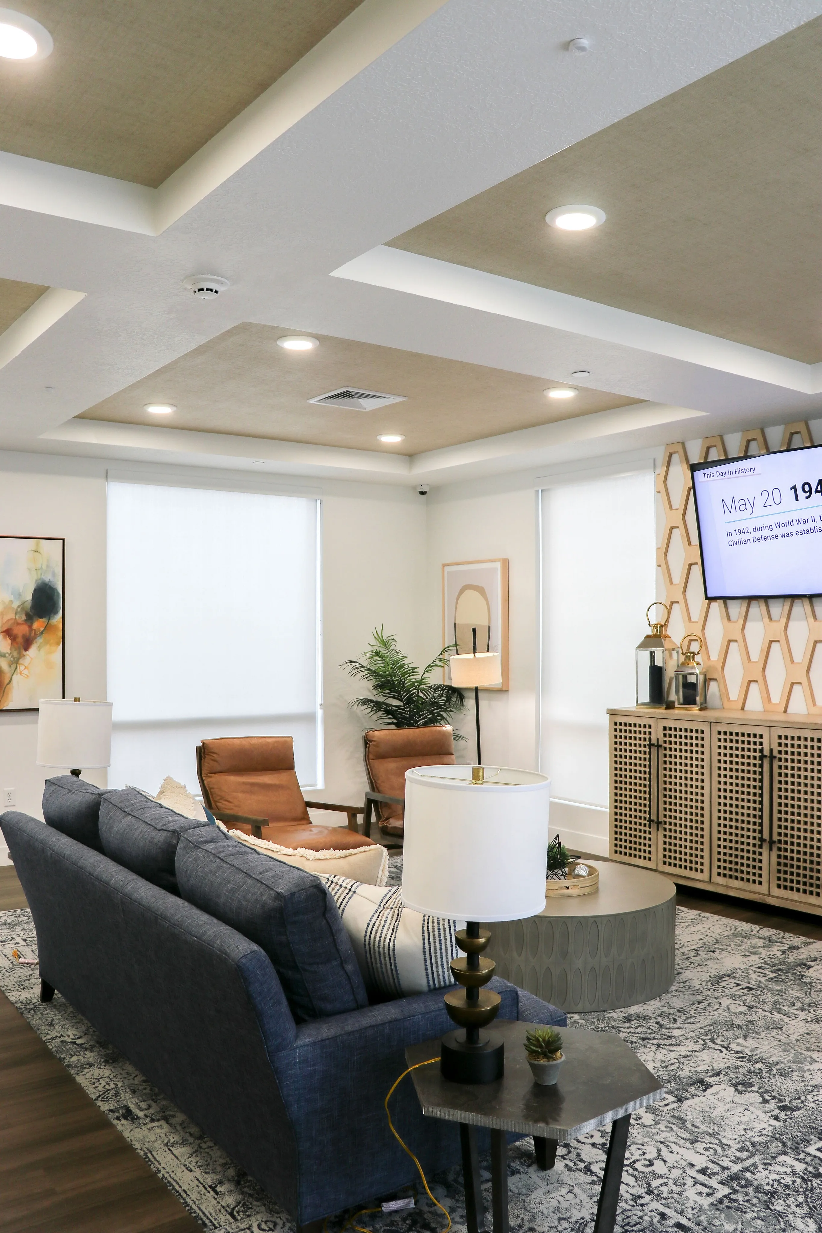 Modern living room with elegant ceiling design, cozy seating area, and stylish decor, featuring a sleek TV display.