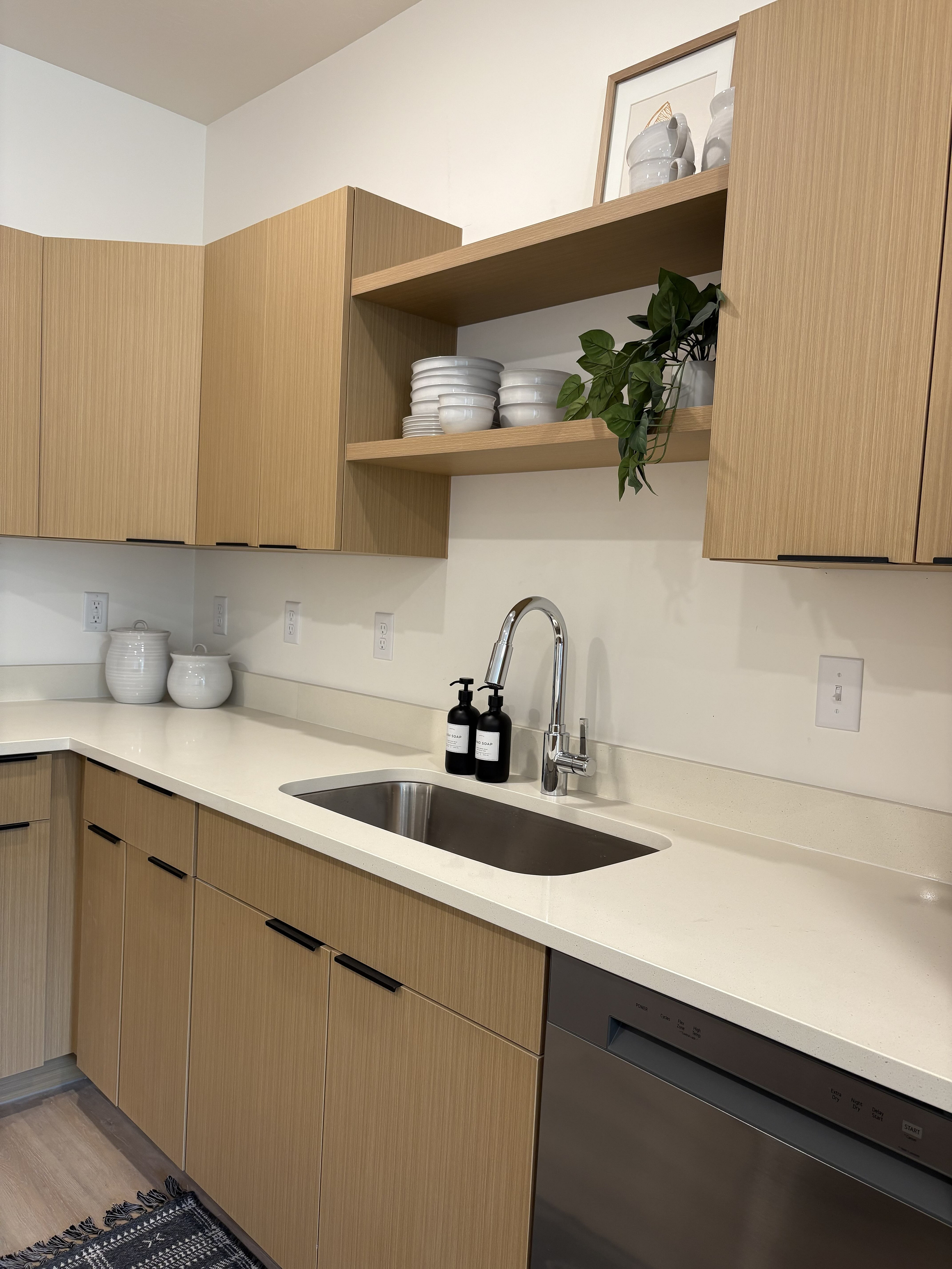 Modern kitchen with elegant wood cabinetry, sleek countertops, and contemporary shelving for a stylish touch.