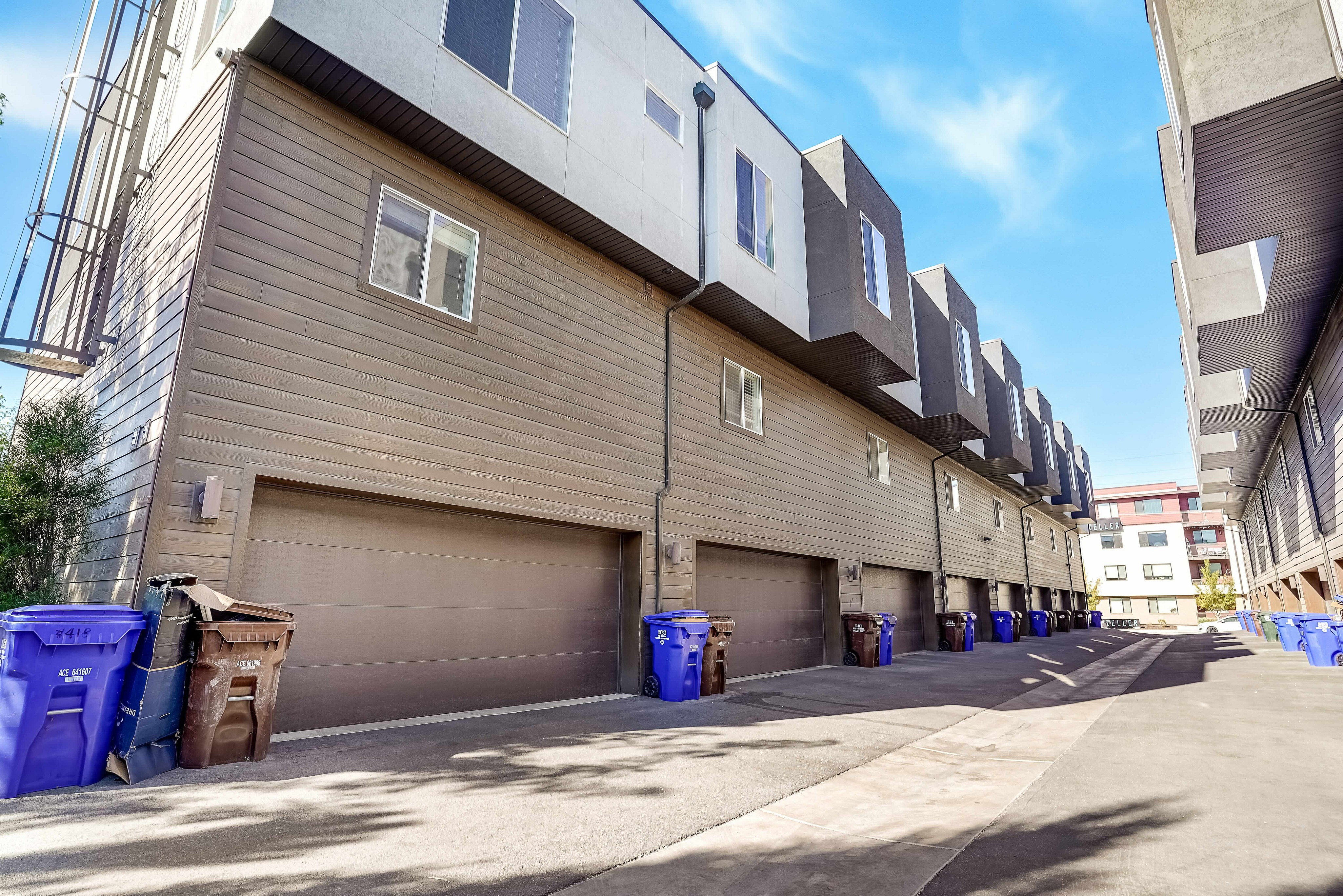 Modern townhouse complex with sleek architecture, featuring spacious garages and vibrant surroundings.