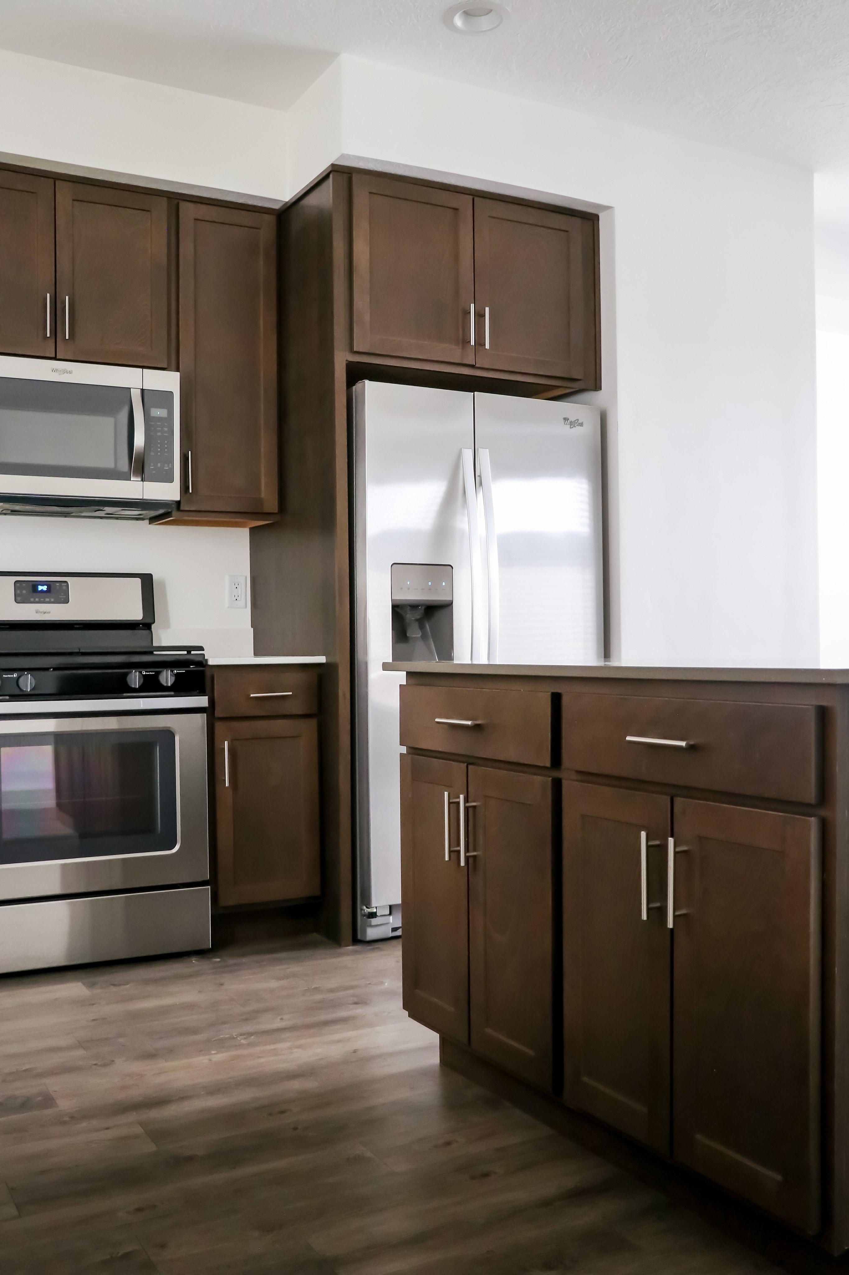Sleek modern kitchen featuring stainless steel appliances, elegant wood cabinetry, and polished hardwood floors.