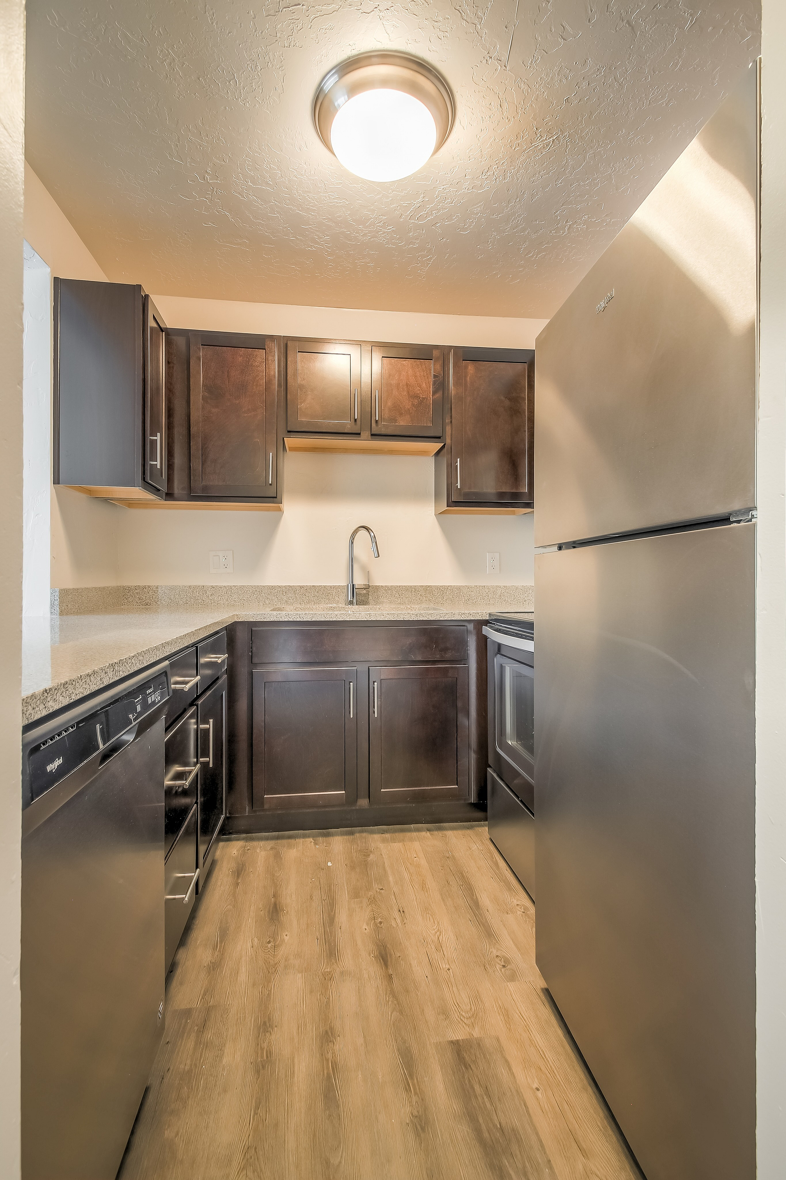 Contemporary kitchen with elegant dark wood cabinets, modern appliances, and sleek countertops, perfect for culinary creativity.